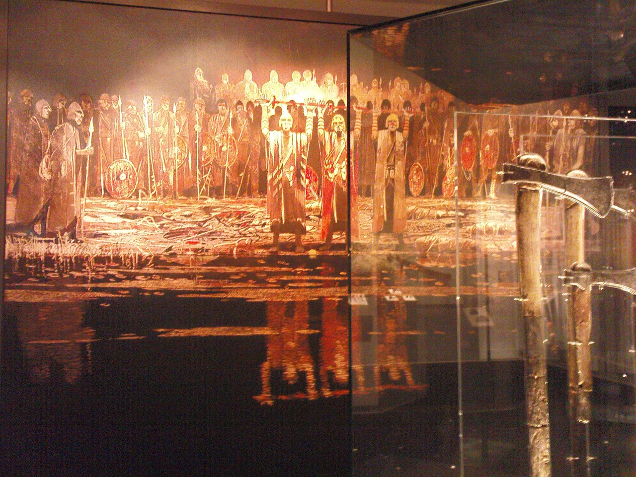 An artists depiction of a votive offering in Illerup Ådal. From an exhibition at Moesgård Museum (Moesgård Manor). Some of the excavated axes can be seen on exhibit at the right.