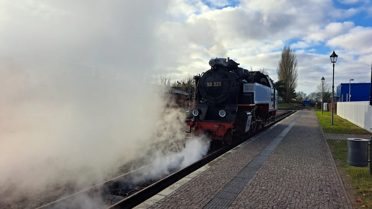 This image shows a train of the narrow-gauge "Molli"-railway in the streets of Bad Doberan.